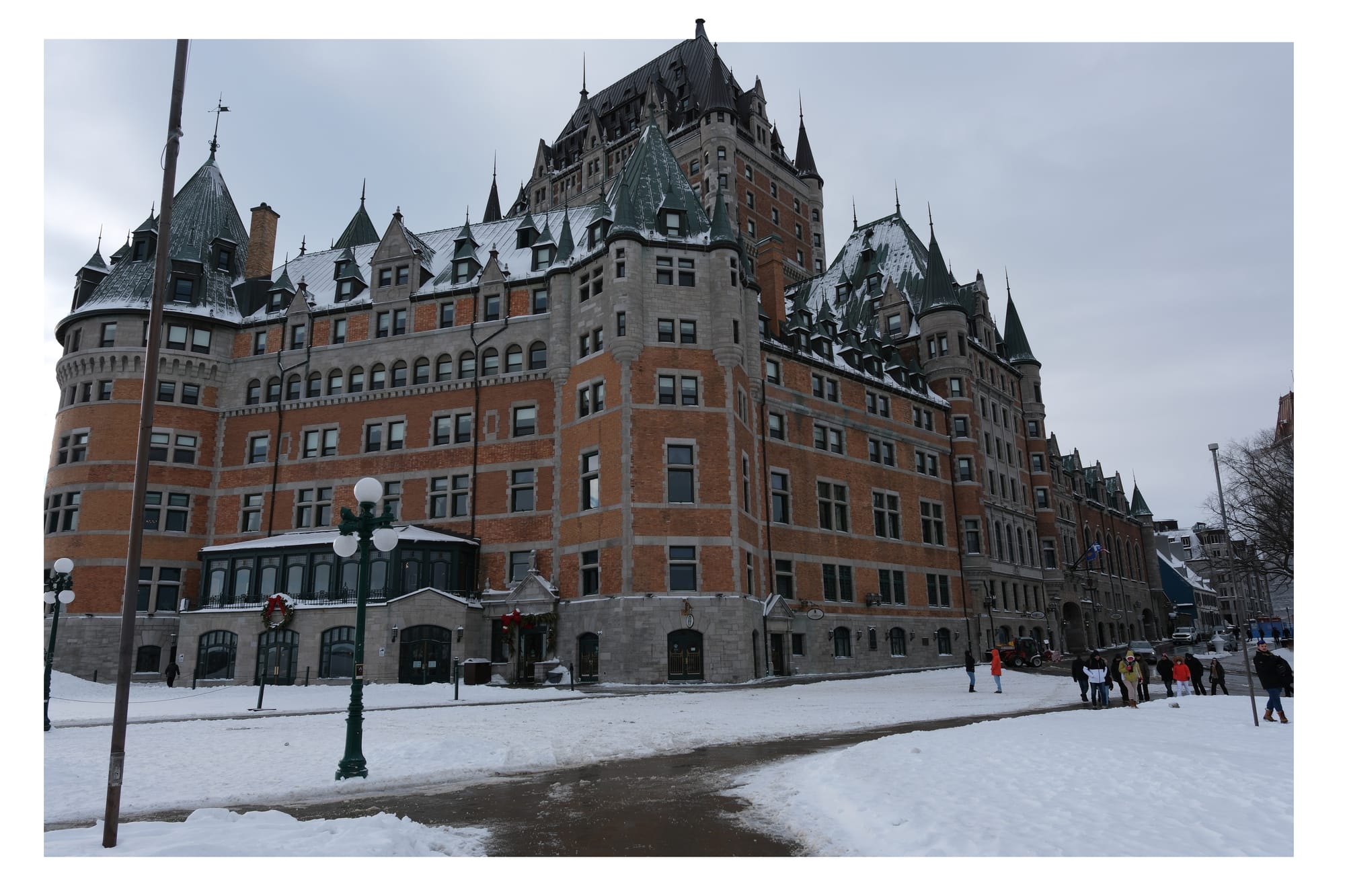 Snow-covered historic château-like building under an overcast winter sky.