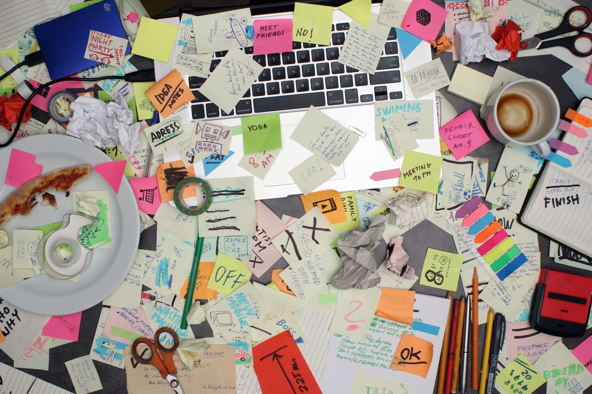 Cluttered desk overwhelmed with tasks symbolizing the need for productivity and time management through effective delegation