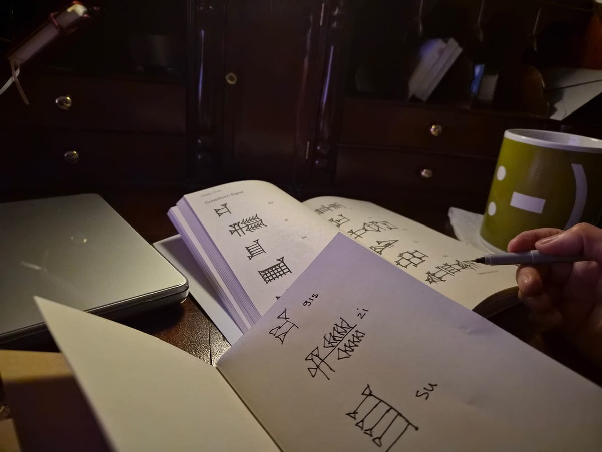 A pre-dawn study setup for learning ancient Sumerian cuneiform, representing the pursuit of difficult but personally meaningful work.